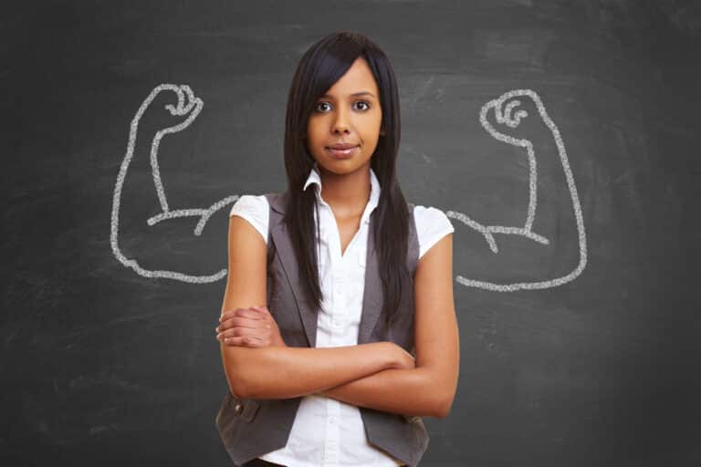 Woman with strong arms drawn on chalkboard behind her