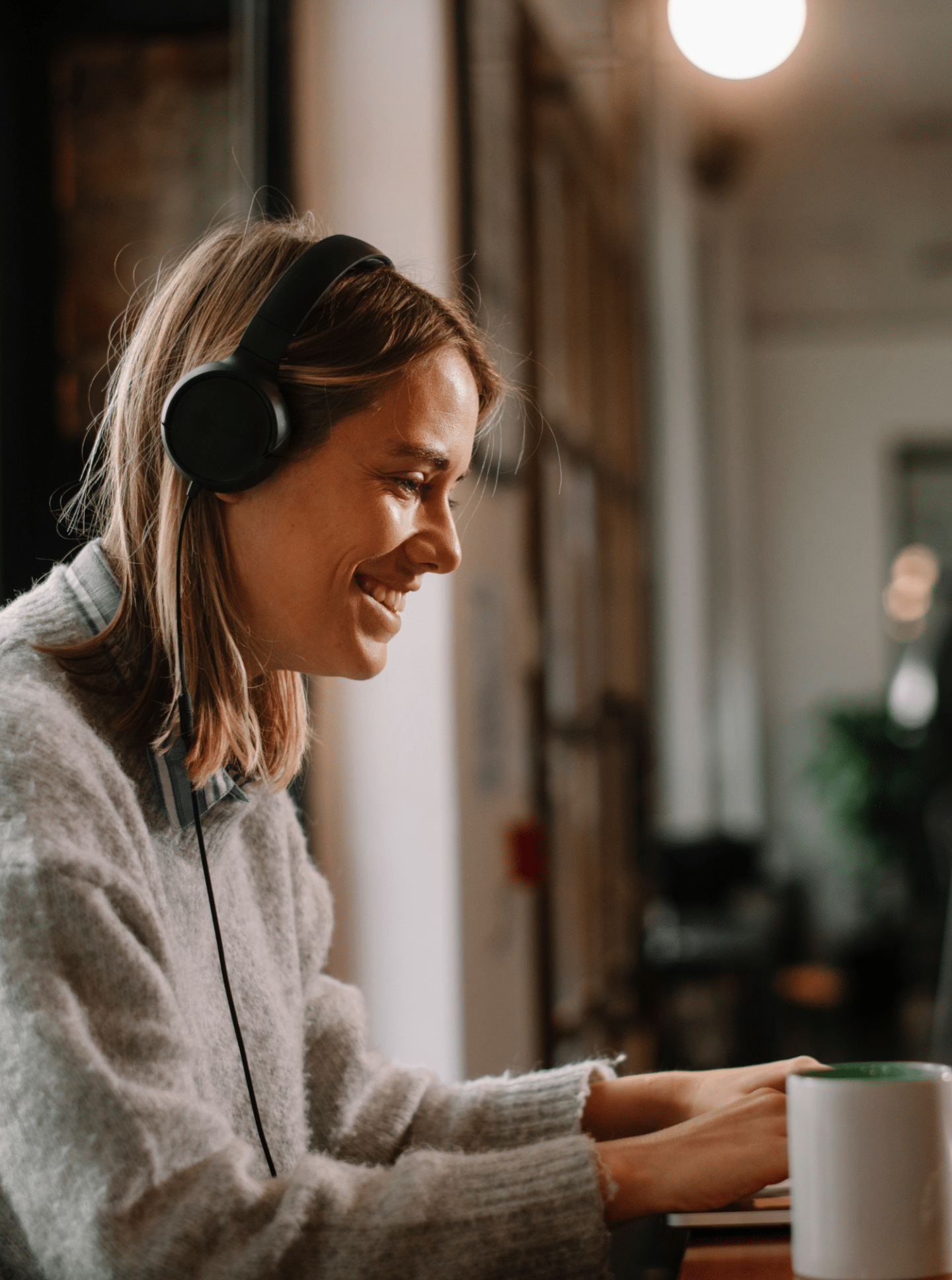 woman working on computer with headphones