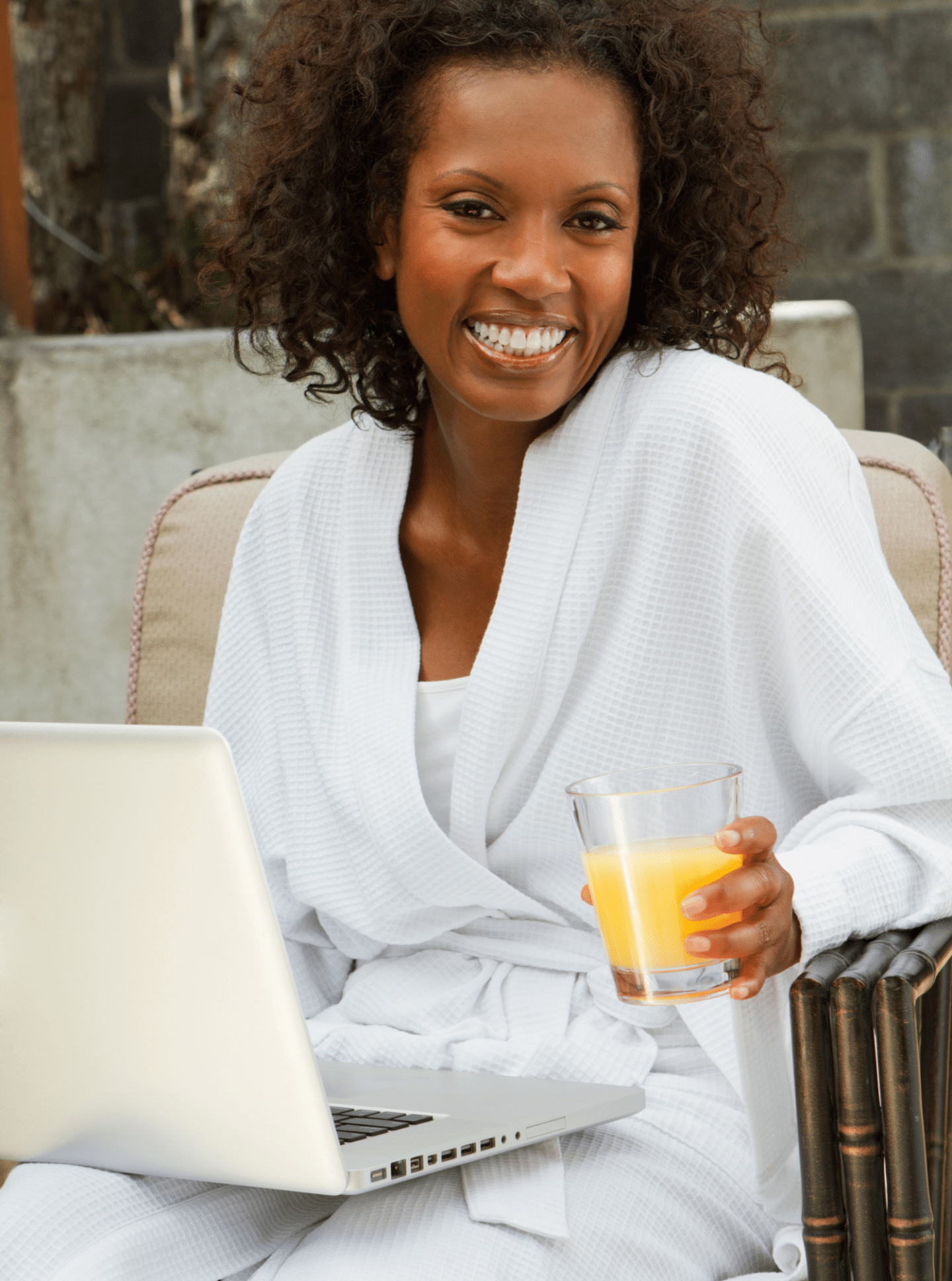 woman smiling with cup in hand and laptop